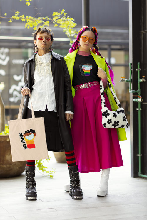 Harajuku-inspired photo of two people, one carrying a canvas tote with the BIPOC solidarity Crush ICE fist, the other with a long pink skirt and a t-shirt with the Rainbow Progress striped Crush ICE fist.