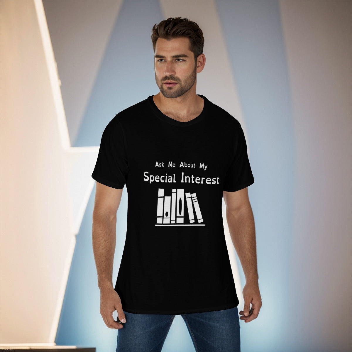 Mockup of a masc-presenting model with short dark hair and evening shadow, wearing a black tshirt with white logo and text. Text: Ask Me About My Special Interest. Logo, below: 6 Stylized books on a shelf.