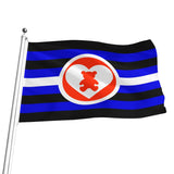 A flag on a silver pole with horizontal black and blue stripes, a white central stripe, and a red circular emblem containing a white heart and red teddy bear, shown on a plain white background.
Note: This flag represents consesual play between adults.