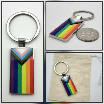 3 Views of a metal keychain. It has a rainbow progress flag design.