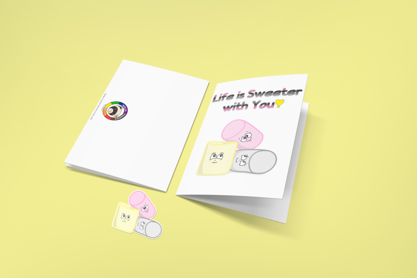 Two greeting cards on a yellow background. The first is flipped to show the back, with the Ninja Ferret Logo. The second has a white background. At the top is the text, "Life is Sweeter with You!" in the queerplatonic pride flag colours. Below are matching pink, yellow, and grey cartoon marshmallows with cute expressions. Below the cards is a matching sticker of three marshmallows.